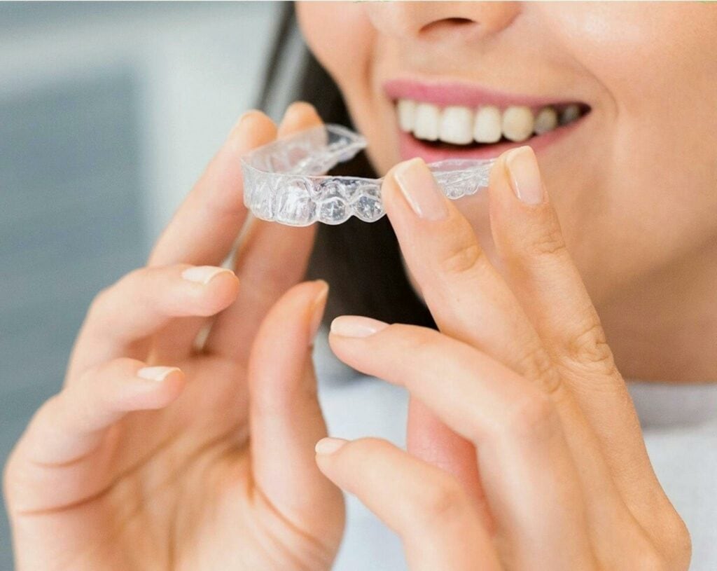 Woman with colorado orthodontist in boulder county, holding invisalign clear aligners